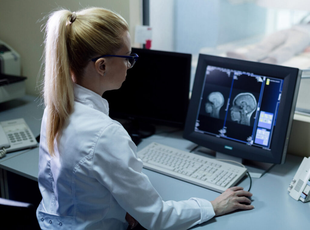 Lekár hodnotí výsledky CT mozgu na monitore