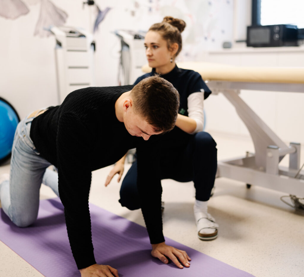 Fyzioterapeutka vedie cvičenie chrbtice s pacientom